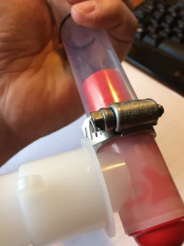 Teflon tube slides over teflon valve body and is secured with a hose clamp.